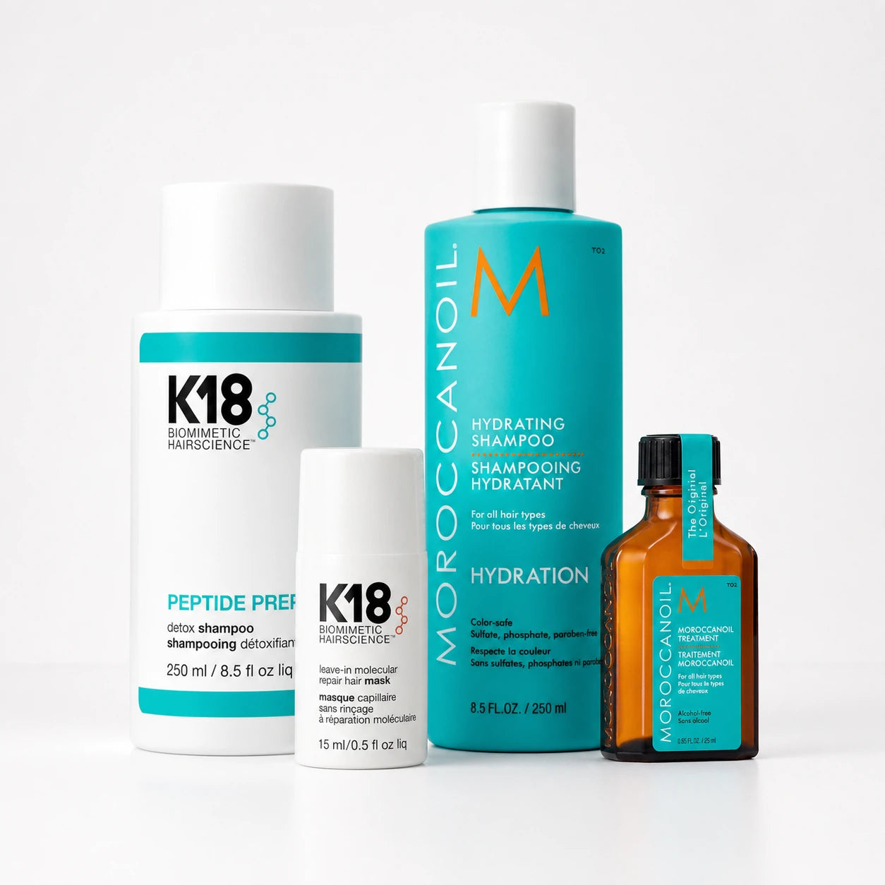K18- ja Moroccanoil-hiustenhoitotuotteita valkoisella studiotaustalla